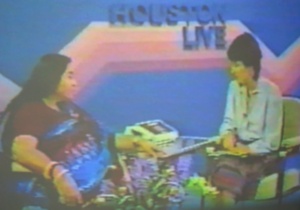 Shri Mataji sitting - with interviewer, flowers and telephone system