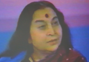 Shri Mataji listening - in crimson and blue sari