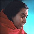 Shri Mataji staring downwards, with a red shawl