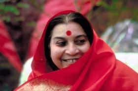 head and shoulders of Shri Mataji, smiling with red shawl