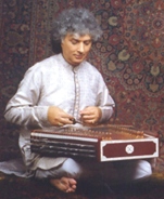 Pandit Shiv Kumar Sharma, sitting cross-legged, playing Santoor on his lap