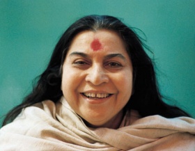 head and shoulders of Shri Mataji, smiling with grey shawl
