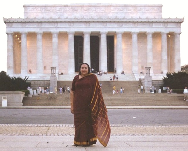 Shri Mataji standing outside Lincoln Memorial, Washington, burgundy and gold sari