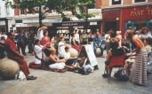 members of the public watch or participate in a street meditation workshop