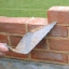 bricklayer's trowel and brick wall under construction