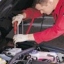 car servicing, mechanic with screwdriver, under the bonnet