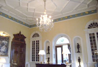 large room with a chandelier, ornate mouldings and decoration
