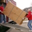 two men carrying a wardrobe up a ramp into a van