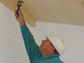 carpenter varnishing softwood ceiling