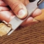hand cutting a sliver of wood with a chisel